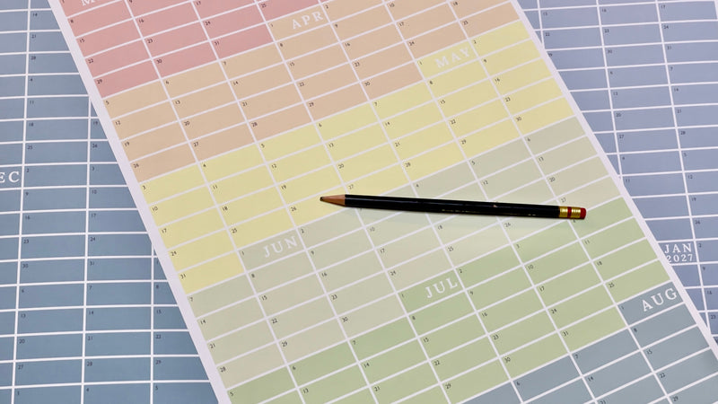 a pencil on top of a continuous academic calendar with multi colors for each cell showing the entire year in one perpetual view. 